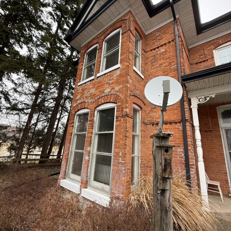 Victorian red brick home with old, inefficient wood-frame windows.